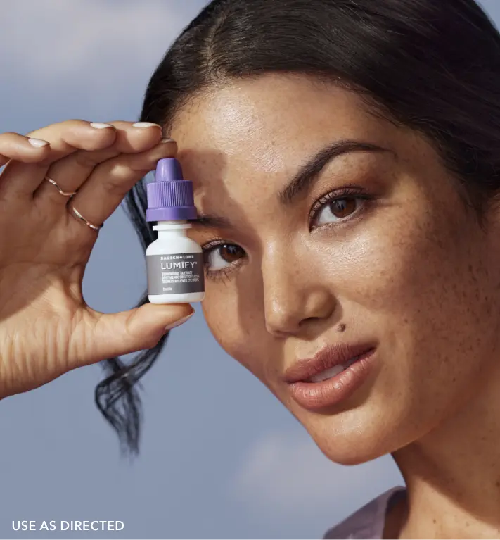 Woman holding a Lumify redness relieving eye drops bottle