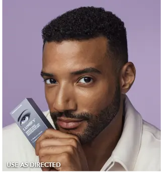 Close up of a man holding Lumify redness relieving eye drops box