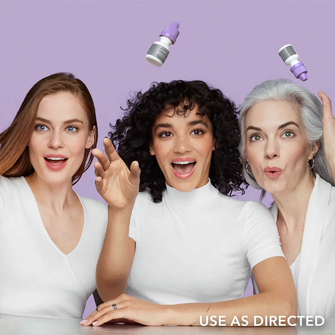 Three women standing next to each other trying to catch falling Lumify products