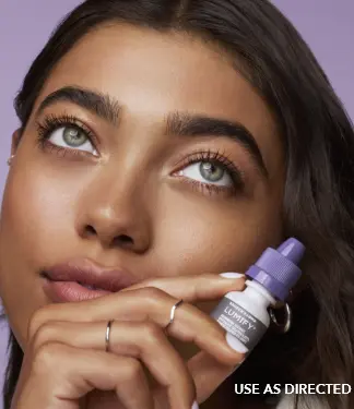 Close up of a woman holding a Lumify eye drops bottle