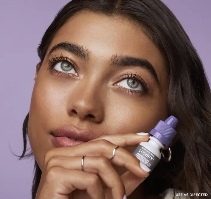 Woman holding Lumify redness reliever eye drops