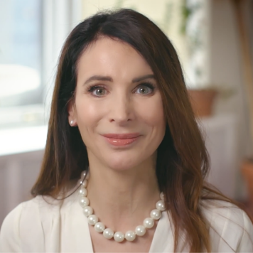 Woman with brown hair wearing pearls