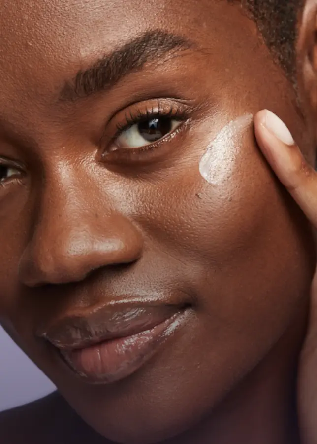 Close up of a woman's face applying Lumify eye cream