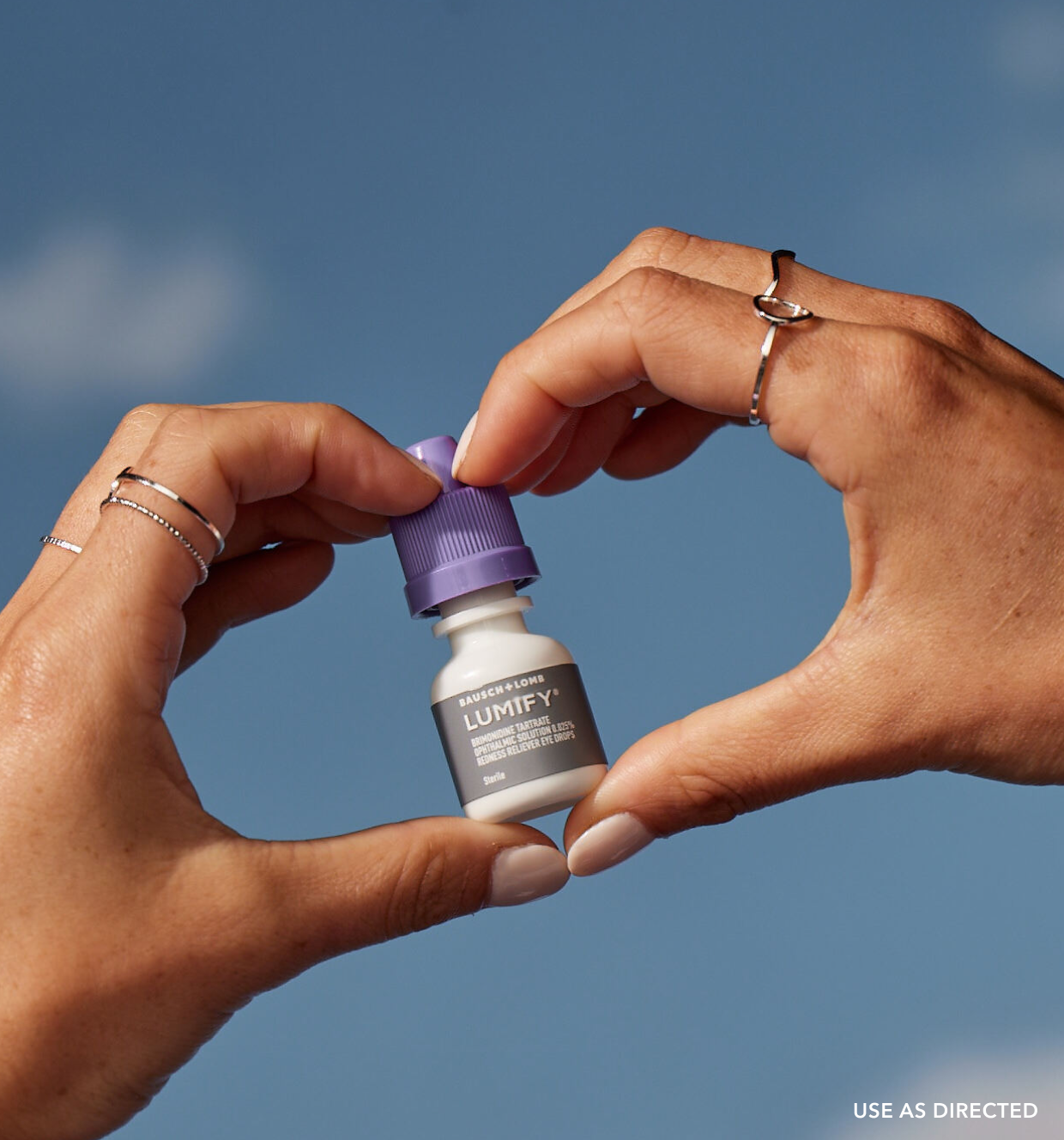Pair of hands holding up a box of Lumify redness reliever eye drops