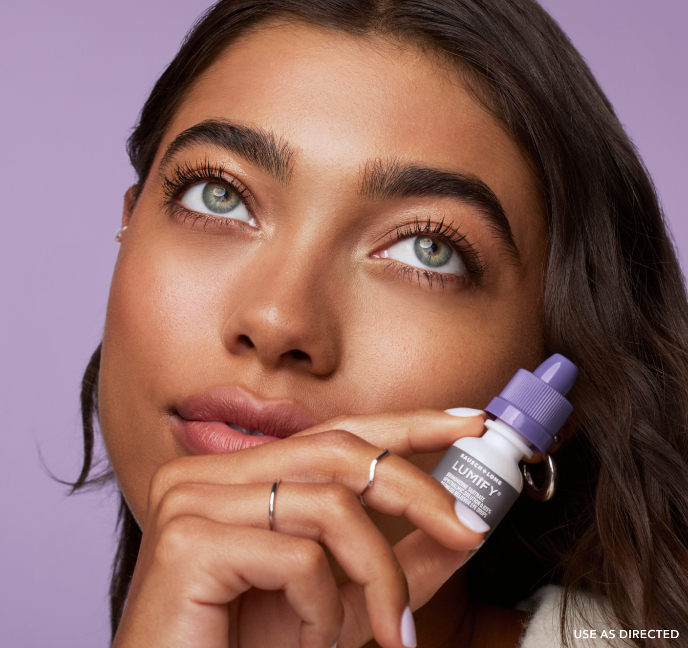 Woman holding Lumify redness reliever eye drops